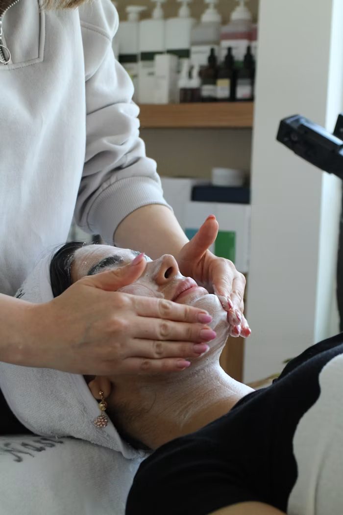 A patient receiving a facial skincare treatment at a skin and wellness studio