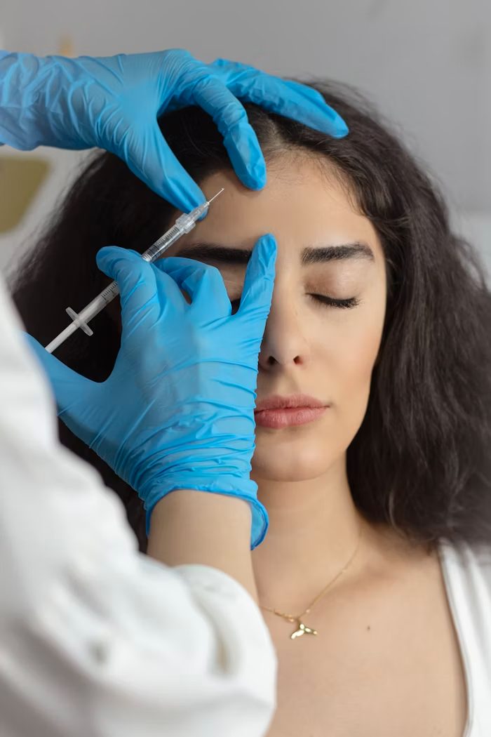 A clinician administering a cosmetic injectable to a patient at an aesthetic clinic